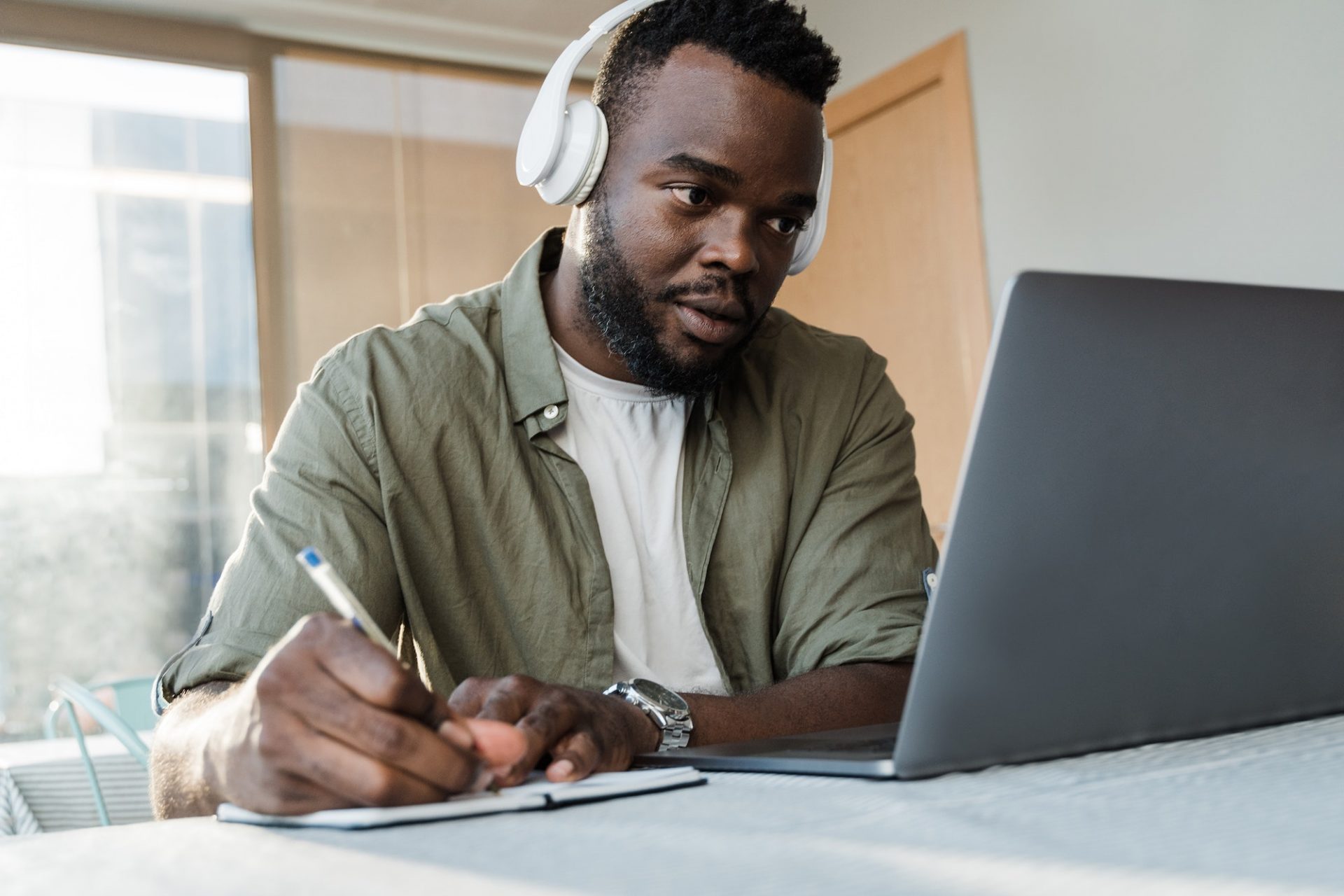 Young african student using computer laptop while studying inside library cafe - Focus on face